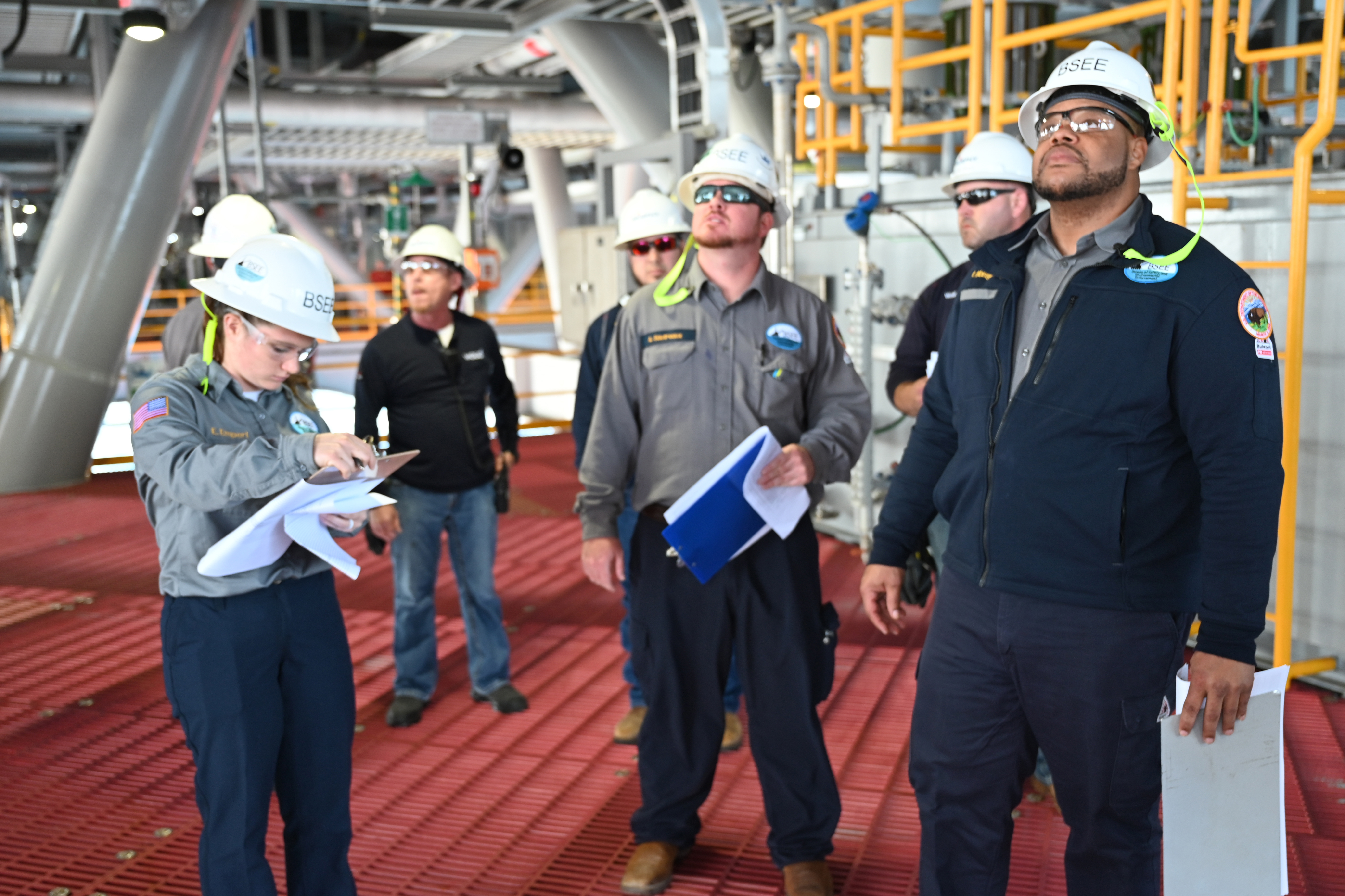 Offshore production inspection team reviewing platform equipment